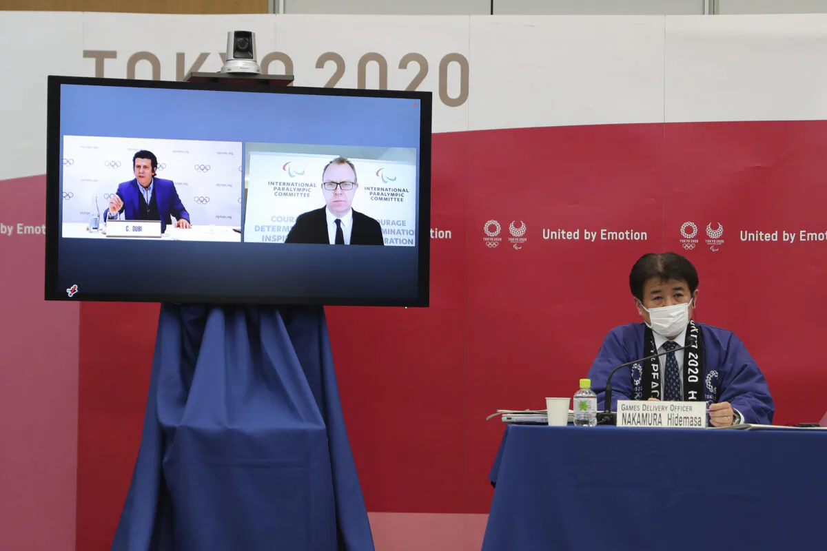Hidemasa Nakamura (R) games delivery officer for the Tokyo Organizing Committee of the Olympic and Paralympic Games (Tokyo 2020), joins other representatives from the International Olympic Committee and the International Paralympic Committee at a joint press briefing in Tokyo on Feb. 3, 2021. (Du Xiaoyi/Pool Photo via AP)