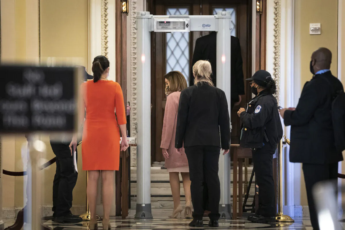 Speaker of the House Nancy Pelosi (D-Calif.) walks through a metal detector before entering the House Chamber at the U.S. Capitol in Washington, on Jan. 21, 2021. (Drew Angerer/Getty Images)