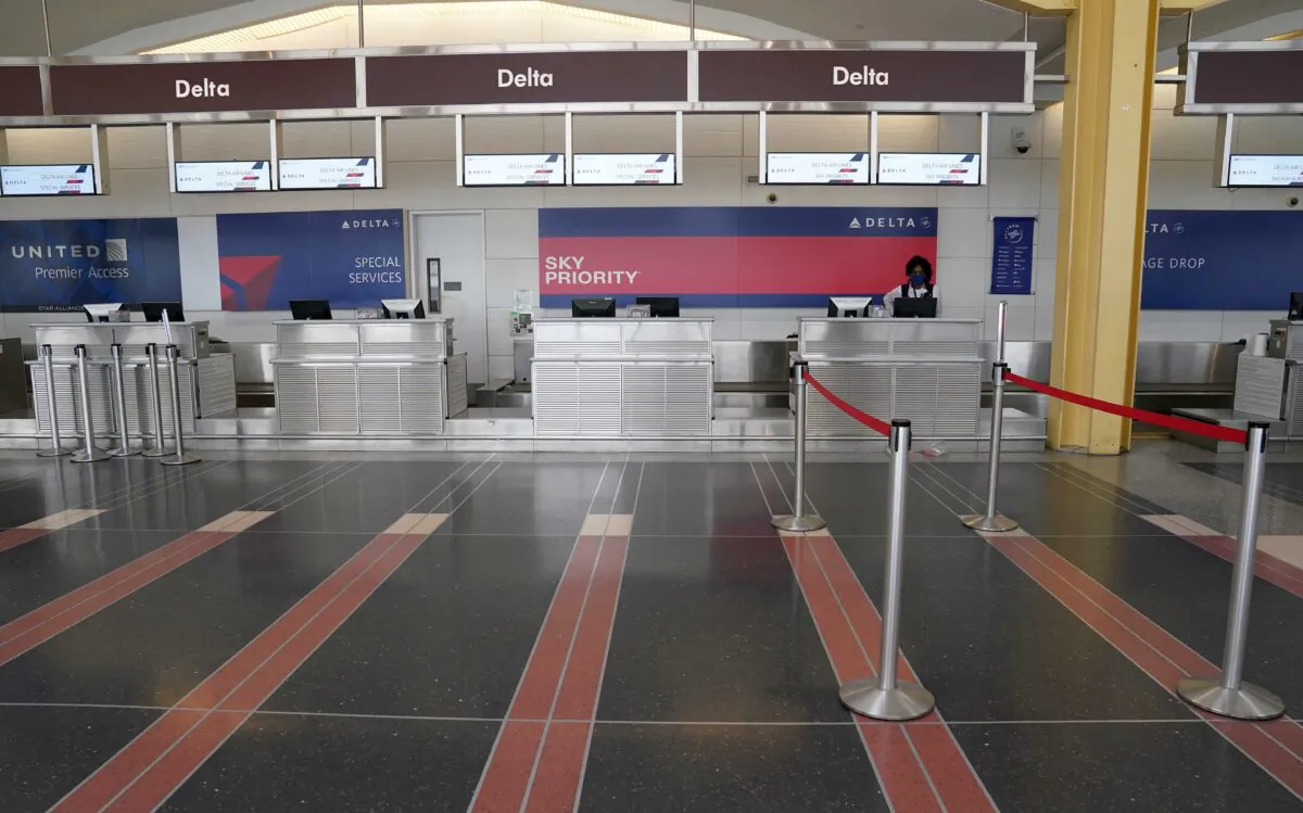 A customer service agent waits for customers at a Delta Airlines check-in counter at Washington’s Reagan National airport, in Washington, on April 29, 2020. (Kevin Lamarque/Reuters)