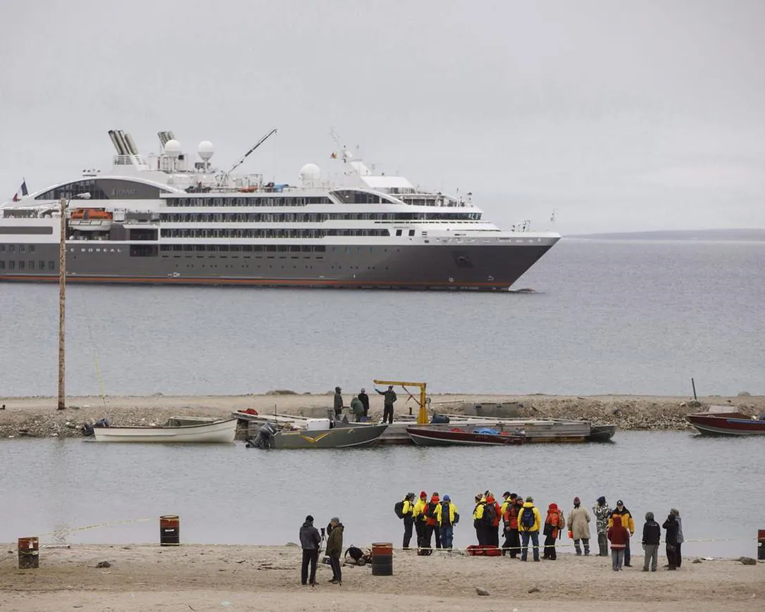 Passengers from a cruise ship reach the shore on zodiac boats during a visit to the town of Gjoa Haven, Nunavut on Sept. 3, 2017. The federal government announced Thursday that a ban on cruise ships in Canadian waters is in place until Feb. 28, 2022. (Jason Franson/The Canadian Press) 