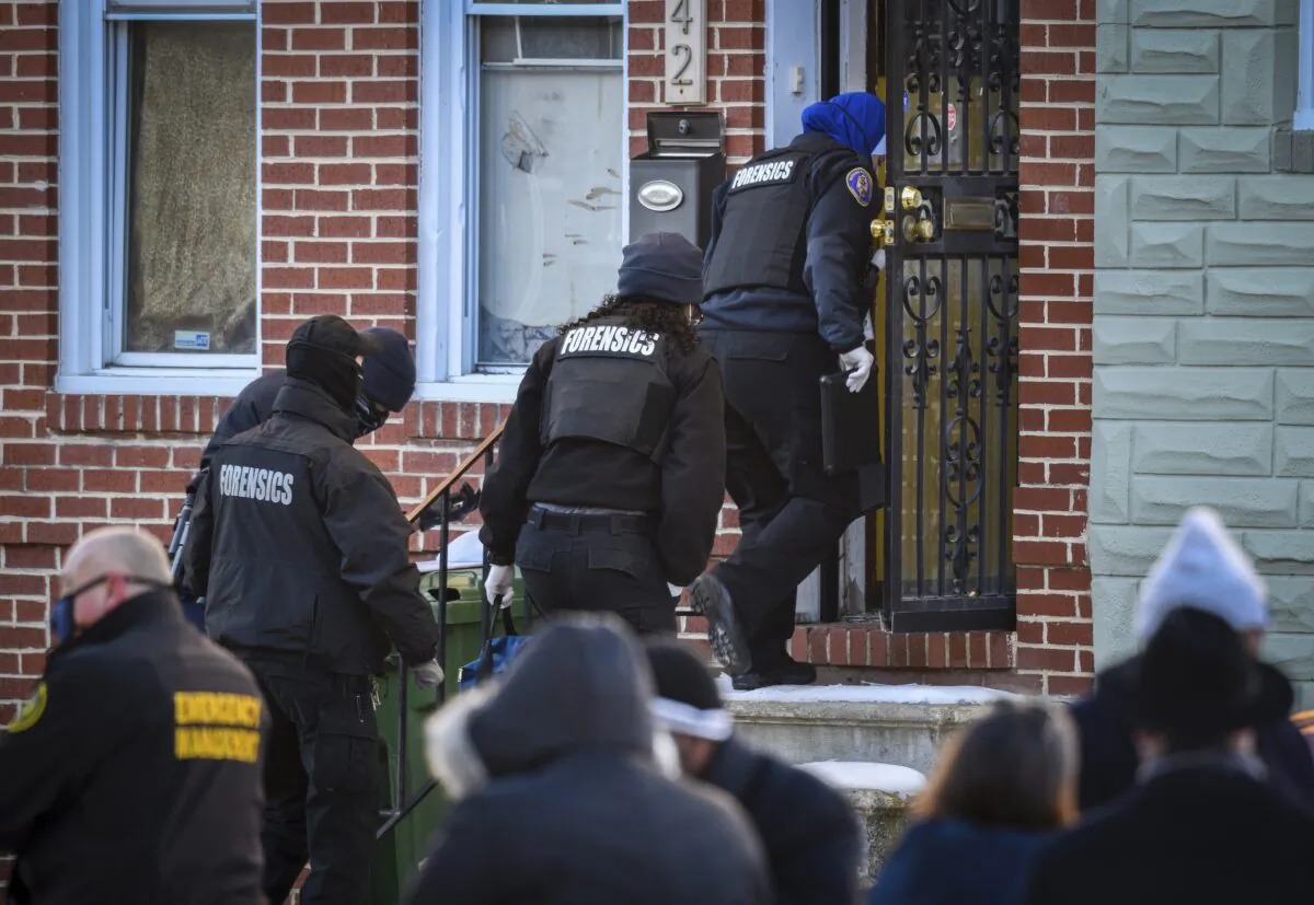A Baltimore Police forensics team enters the house in West Baltimore where a U.S. Marshall was shot while serving an arrest warrant on Feb. 4, 2021. (Jerry Jackson/The Baltimore Sun via AP)