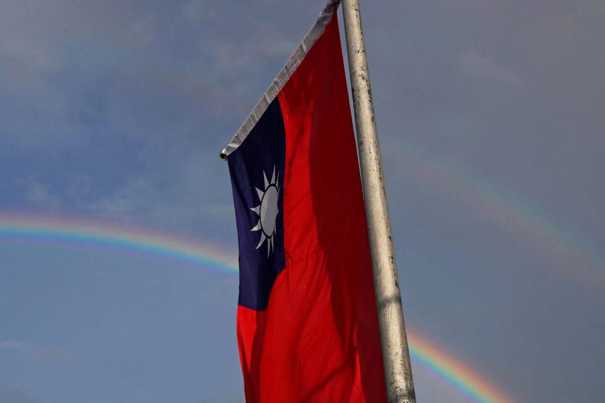 A double rainbow is seen behind Taiwanese flag during the National Day celebrations in Taipei, Taiwan, on Oct. 10, 2017. (Tyrone Siu/Reuters)