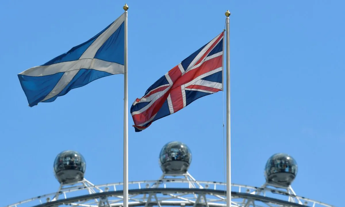 The Scottish Saltire flag flies next to the British Union Jack flag with the London Eye wheel seen behind in London, on July 29, 2019. (Toby Melville/Reuters)