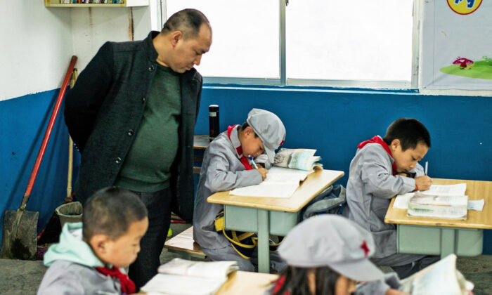 A teacher supervising students in the Yang Dezhi "Red Army" elementary school in Wenshui, Xishui County, in Guizhou Province, China, on Nov. 7, 2016. (Fred Dufour/AFP via Getty Images)