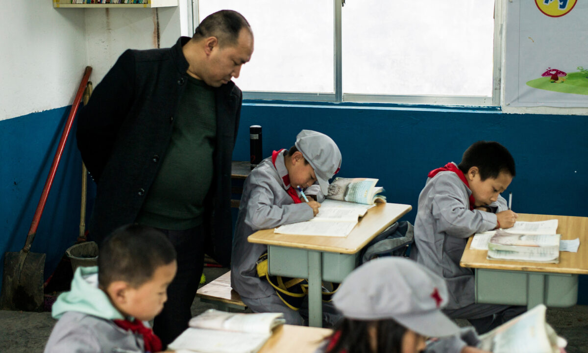 A teacher supervising students in the Yang Dezhi "Red Army" elementary school in Wenshui, Xishui County, in Guizhou Province, China, on Nov. 7, 2016. (FRED DUFOUR/AFP via Getty Images)