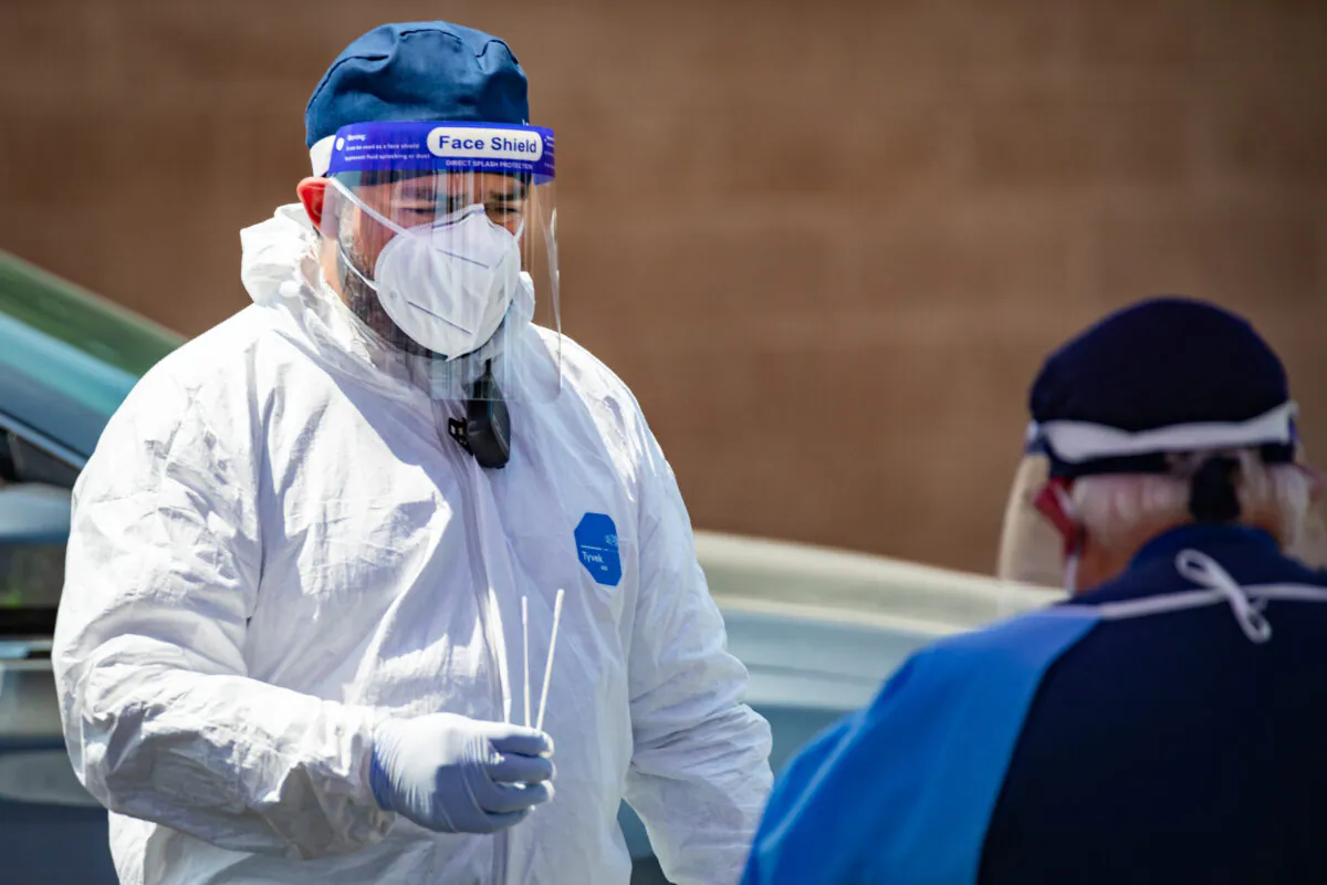 Teledentist Parsia Jahanbani hands an adiministered coronavirus testing kit to medical personal in Anaheim, Calif. on 08.25.2020. (John Fredricks/The Epoch Times)