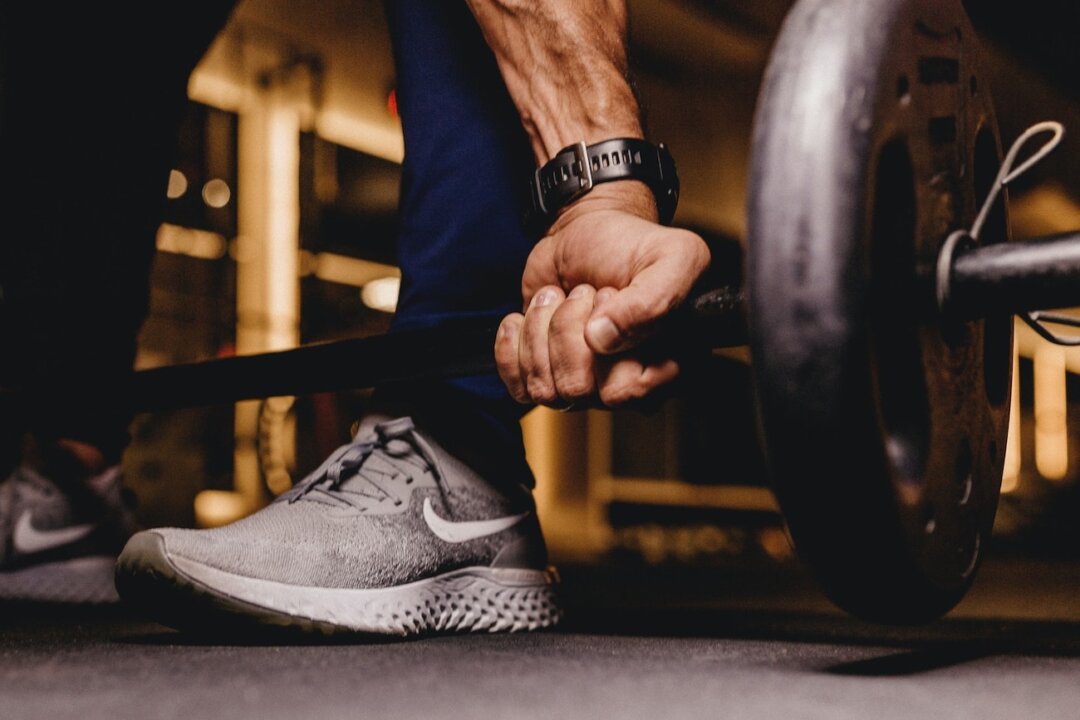 Stock image of a person lifting weights. (Jonathan Borba/Unsplash)