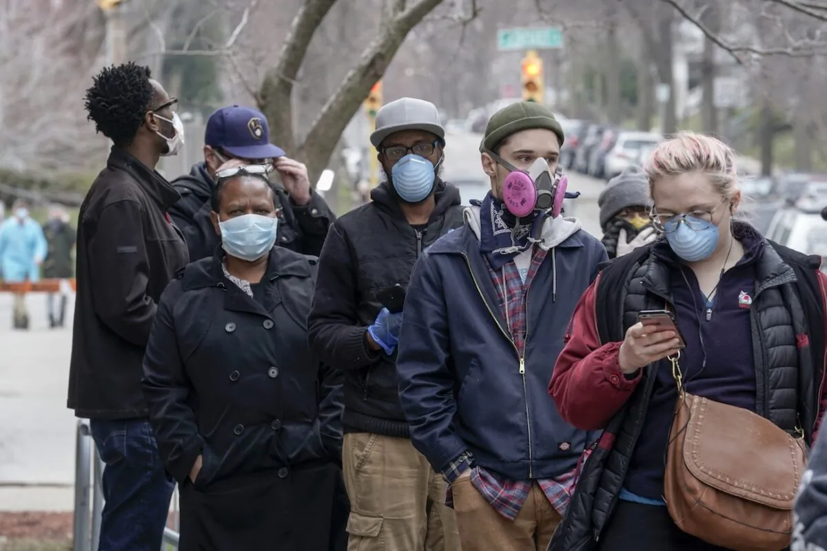 People wear masks in a file photo. (Morry Gash/AP Photo)