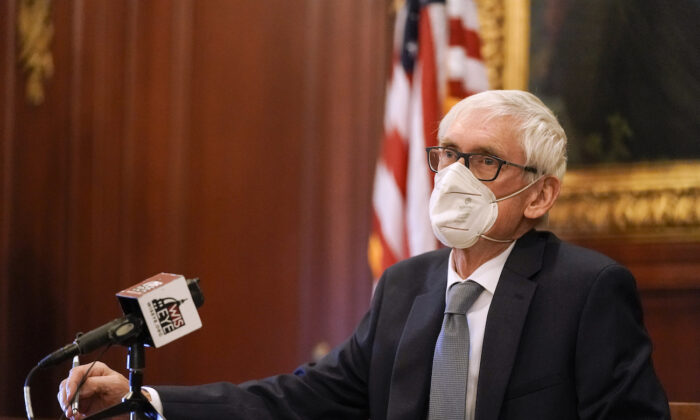 Wisconsin Gov. Tony Evers, a member of Wisconsin's Electoral College, cast his vote at the state Capitol in Madison, Wis., on Dec. 14, 2020. (AP Photo/Morry Gash, Pool)