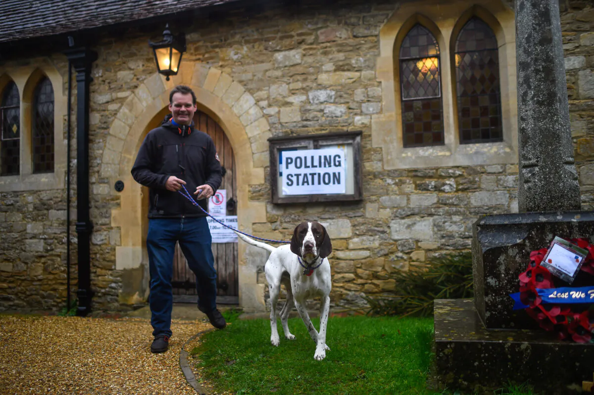 A voter with a dog leaves after casting his ballot paper at a polling station inside a church near Oxford, United Kingdom, on Dec. 12, 2019. (Peter Summers/Getty Images)