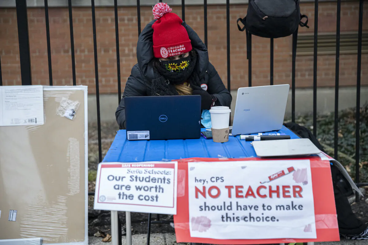 Elementary 1 teacher Melissa Vozar sits outside of Suder Elementary in Chicago to teach a virtual class on Jan. 11, 2021. (Anthony Vazquez/Chicago Sun-Times via AP)