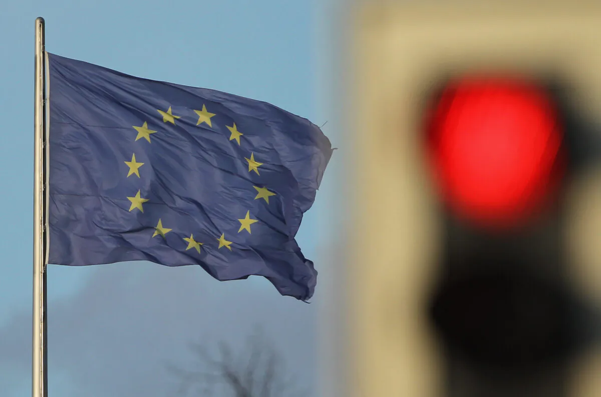 A flag of the European Union waves in the wind near a traffic light showing red in Berlin, Germany, on Nov. 30, 2011. (Sean Gallup/Getty Images)