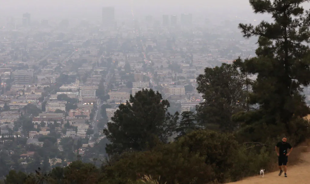 A man walks after sunset amid smoke from wildfires at Griffith Park on September 13, 2020 in Los Angeles, Calif. Air quality was deemed ’unhealthy for sensitive groups’ in the metropolitan area as California's national forests remained closed due to wildfires. (Photo by Mario Tama/Getty Images)