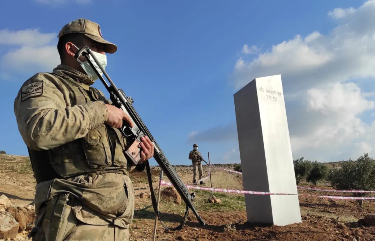 Turkish police officers guard a monolith, found on an open field near Sanliurfa, southeastern Turkey, on Feb. 7, 2021. (Bekir Seyhanli/IHA via AP)