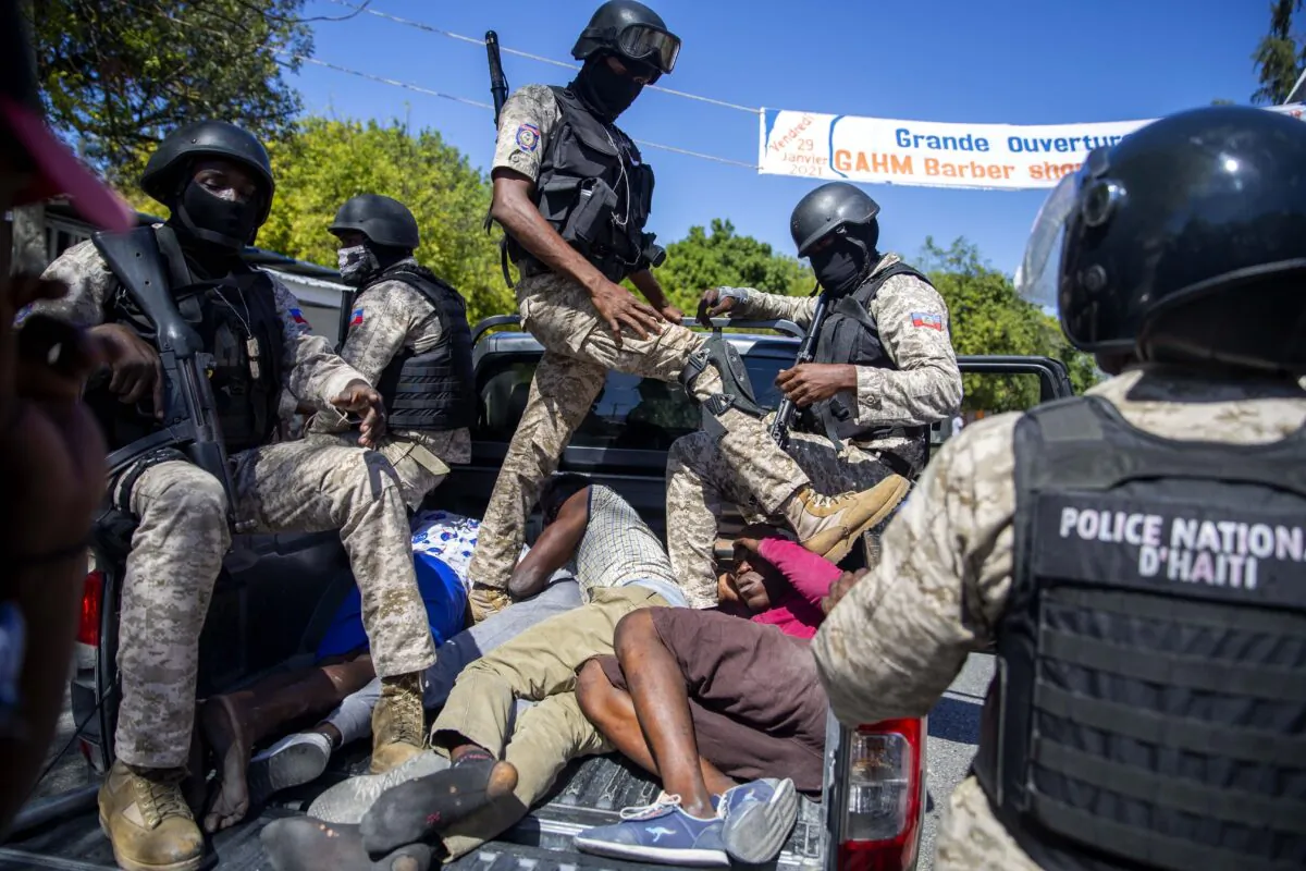 Police move detained demonstrators in the bed of a pick-up truck to a police station during a protest to demand the resignation of Haitian President Jovenel Moise in Port-au-Prince, Haiti, on Feb. 7, 2021. (Dieu Nalio Chery/AP Photo)