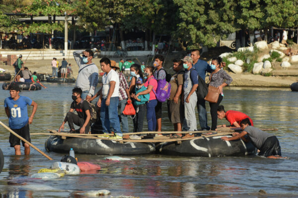 People cross the Suchiate River on a raft