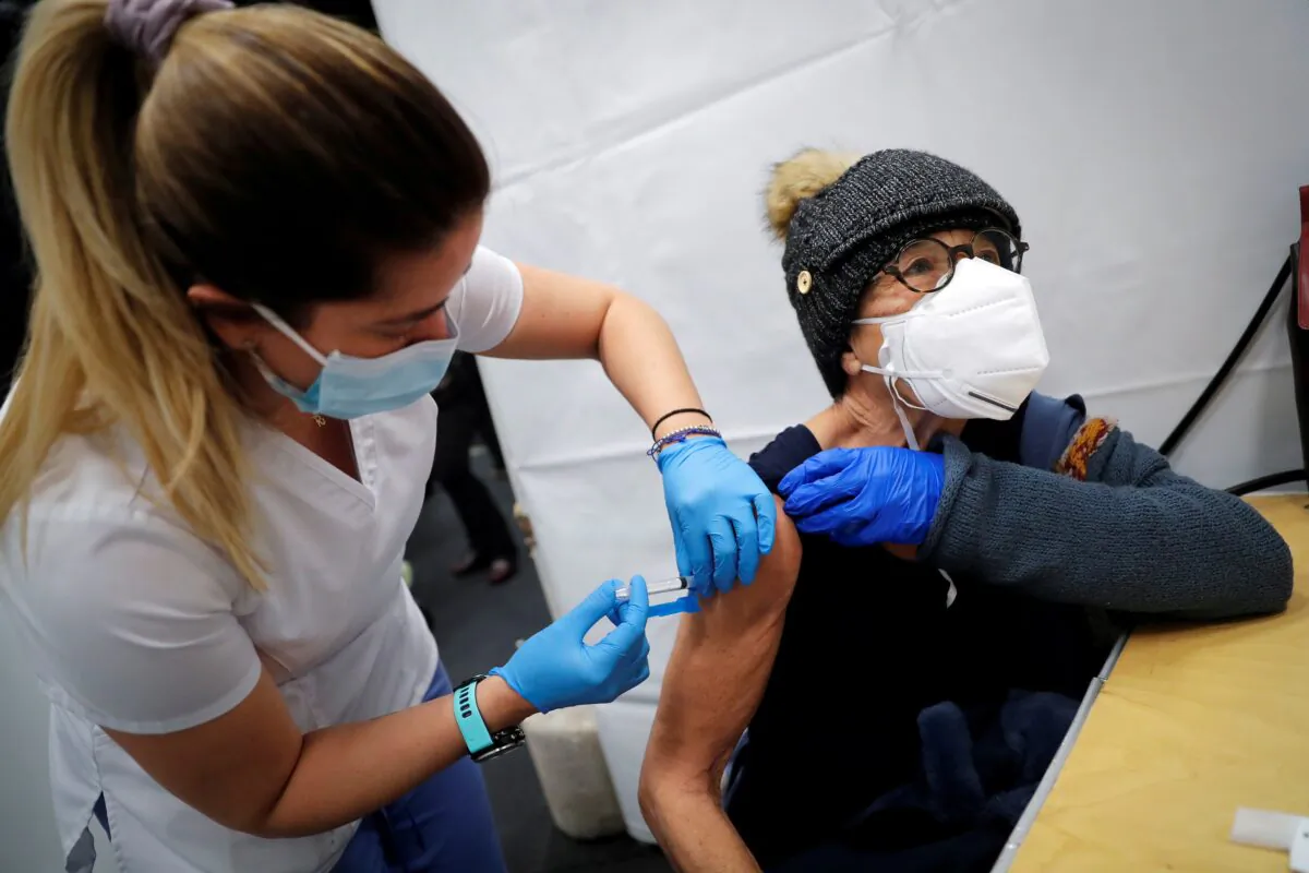 A health care worker administers a shot of a COVID-19 vaccine to a woman in Manhattan, New York City, on Jan. 29, 2021. (Mike Segar/Reuters)