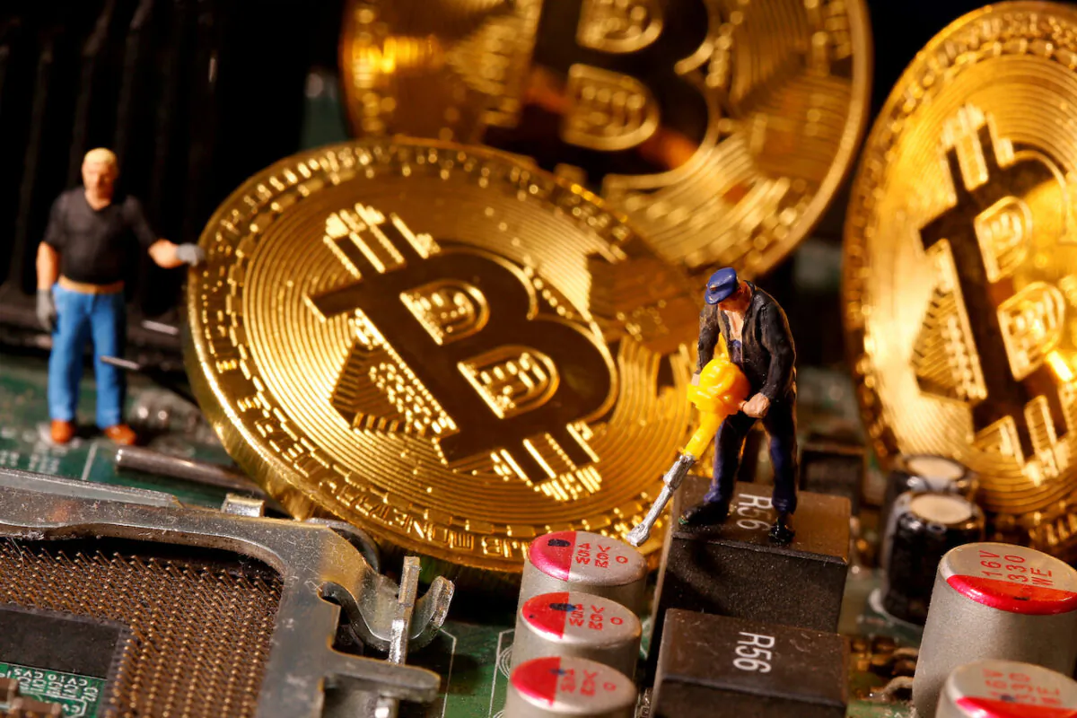 A representation of virtual currency Bitcoin and small toy figures are placed on computer motherboard in this illustration taken on Jan. 7, 2021. (Dado Ruvic/Reuters)