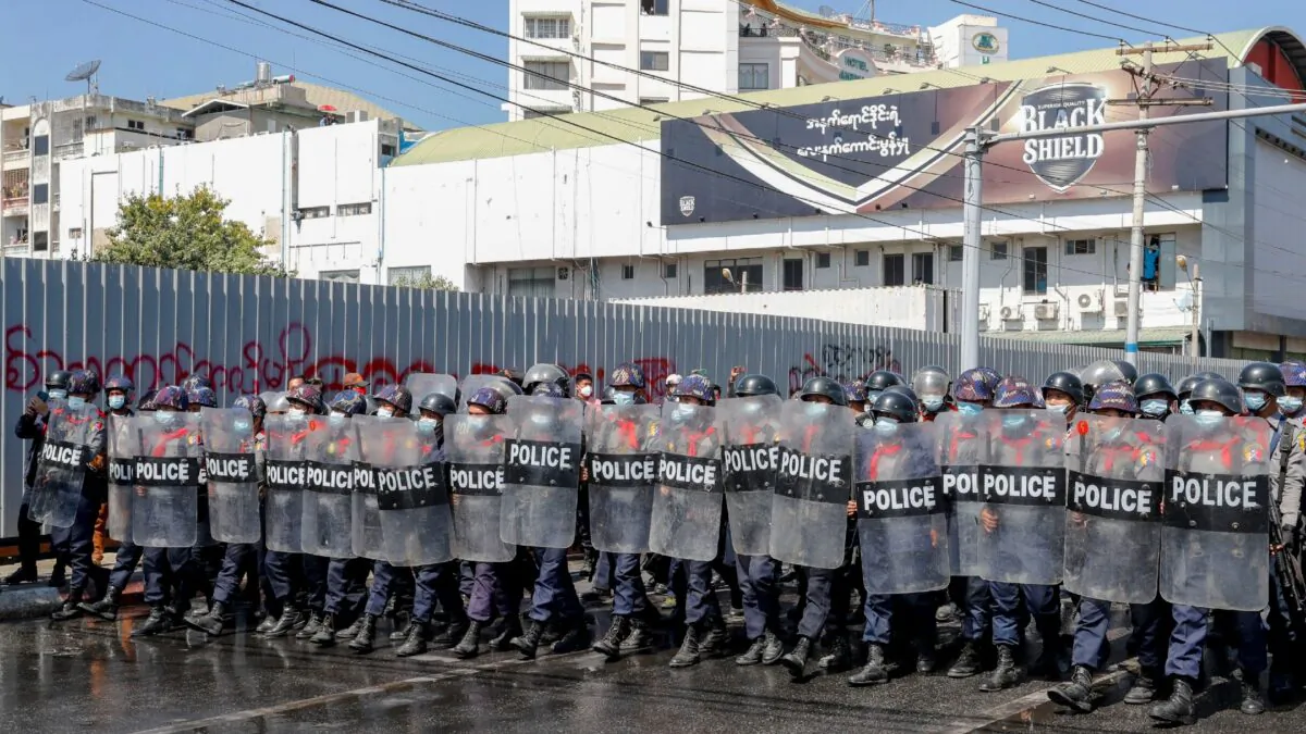 Police in riot gear march to take a position to block demonstrators at an intersection during a protest in Mandalay, Burma, on Feb. 9, 2021. (AP Photo)
