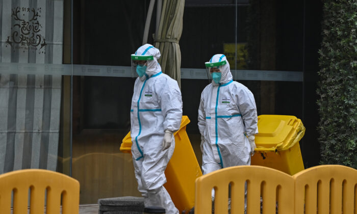 Workers wearing protective gear are seen in the compounds of The Jade Boutique Hotel, where members of the World Health Organization (WHO) team investigating the origins of the COVID-19 pandemic are due to complete their quarantine, in Wuhan, China, on Jan. 28, 2021. (Hector Retamal/AFP via Getty Images)