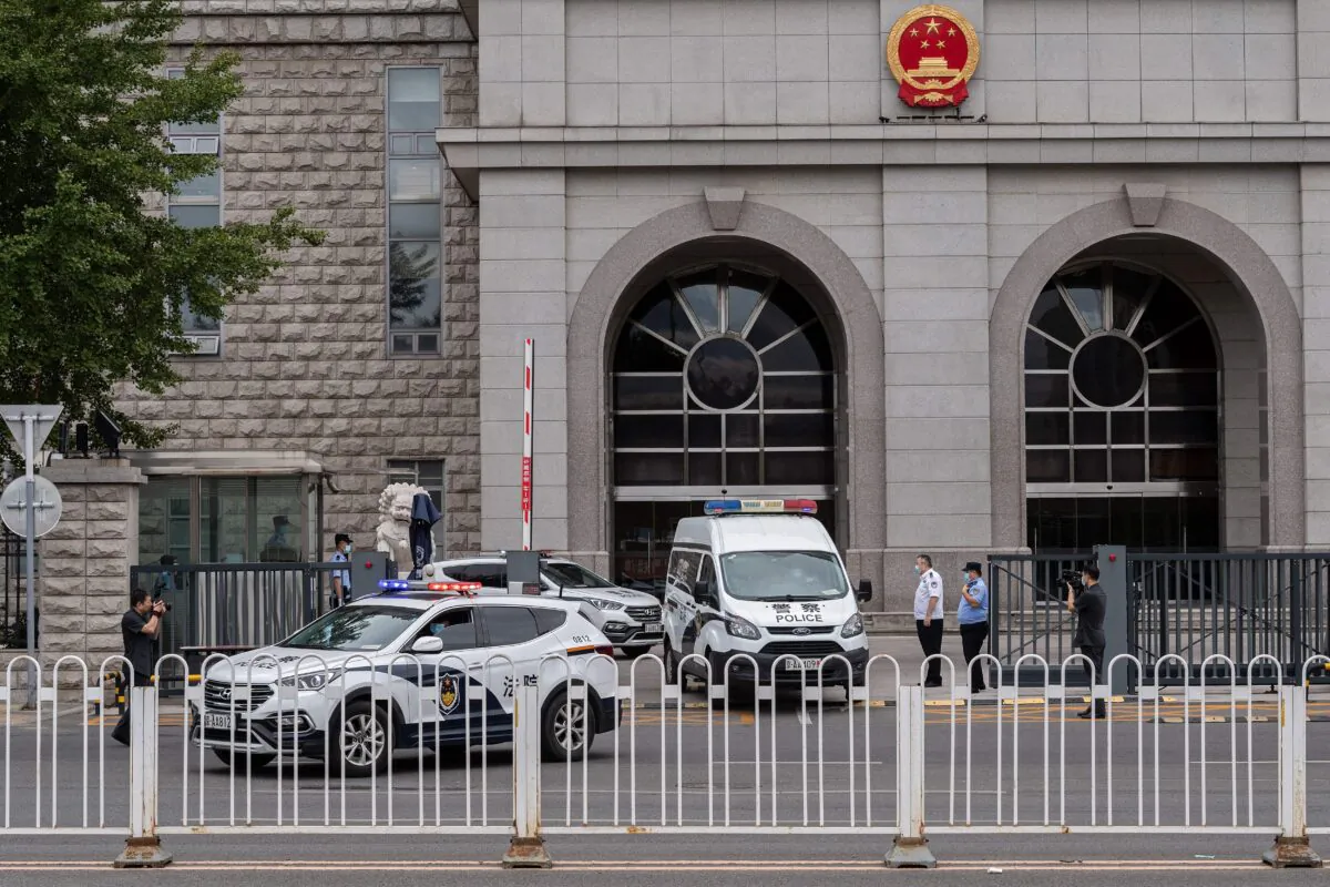 Police vans parked outside a court in Beijing on Sept. 11, 2020. (NICOLAS ASFOURI/AFP via Getty Images)