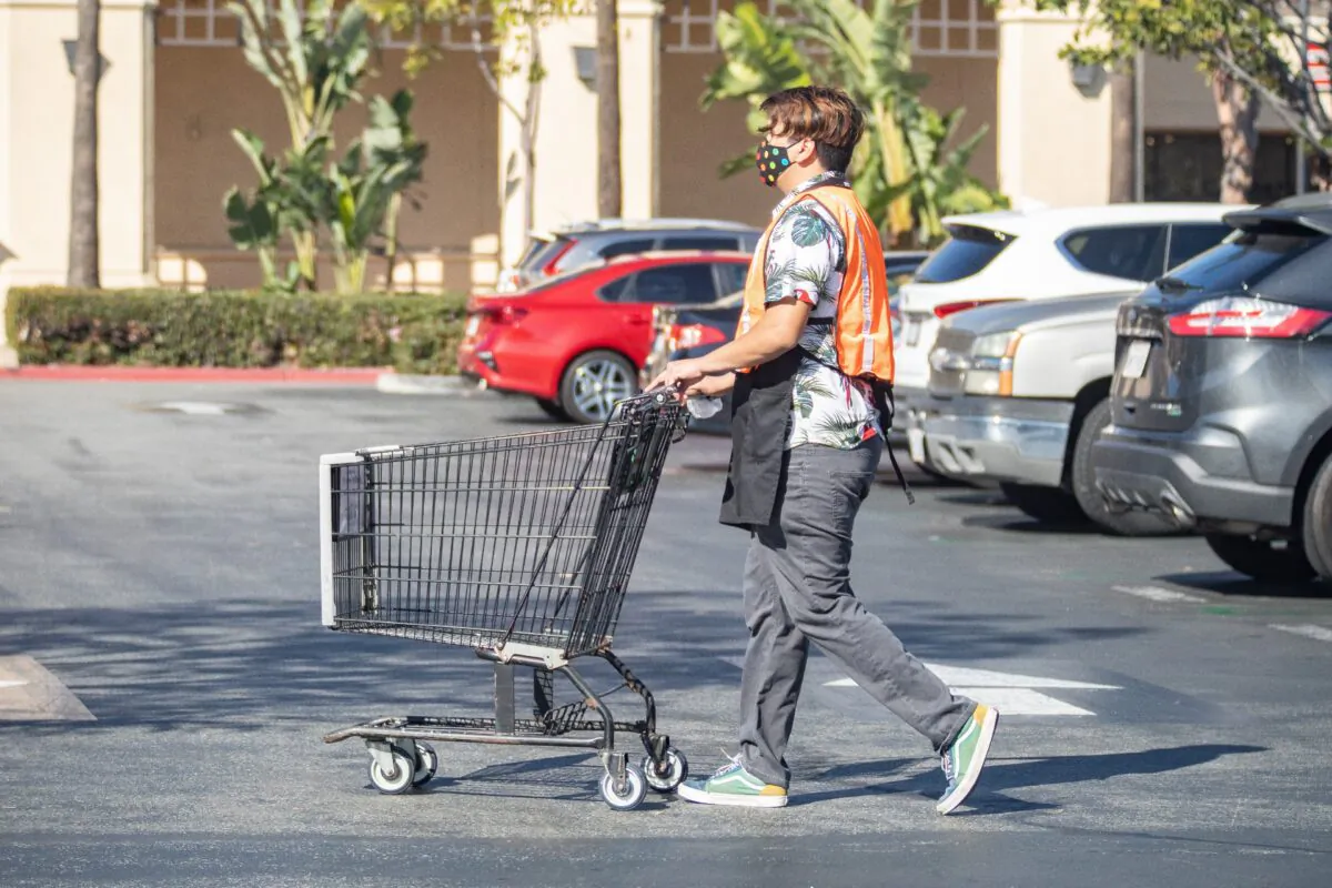A worker at Ralphs returns a shopping cart to the store in Irvine, Calif., on Feb. 5, 2021. (John Fredricks/The Epoch Times)