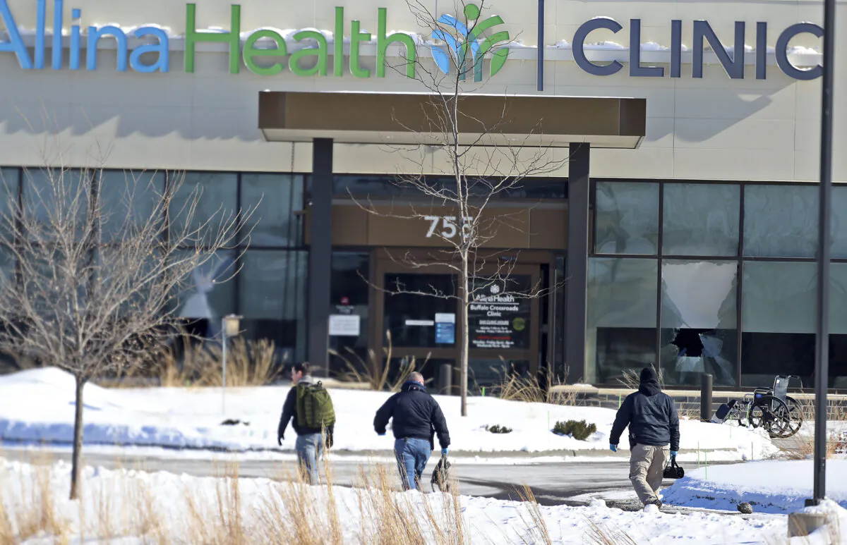 Law enforcement personnel walk toward the Allina Health clinic in Buffalo, Minn., on Feb. 9, 2021. (David Joles/Star Tribune via AP)
