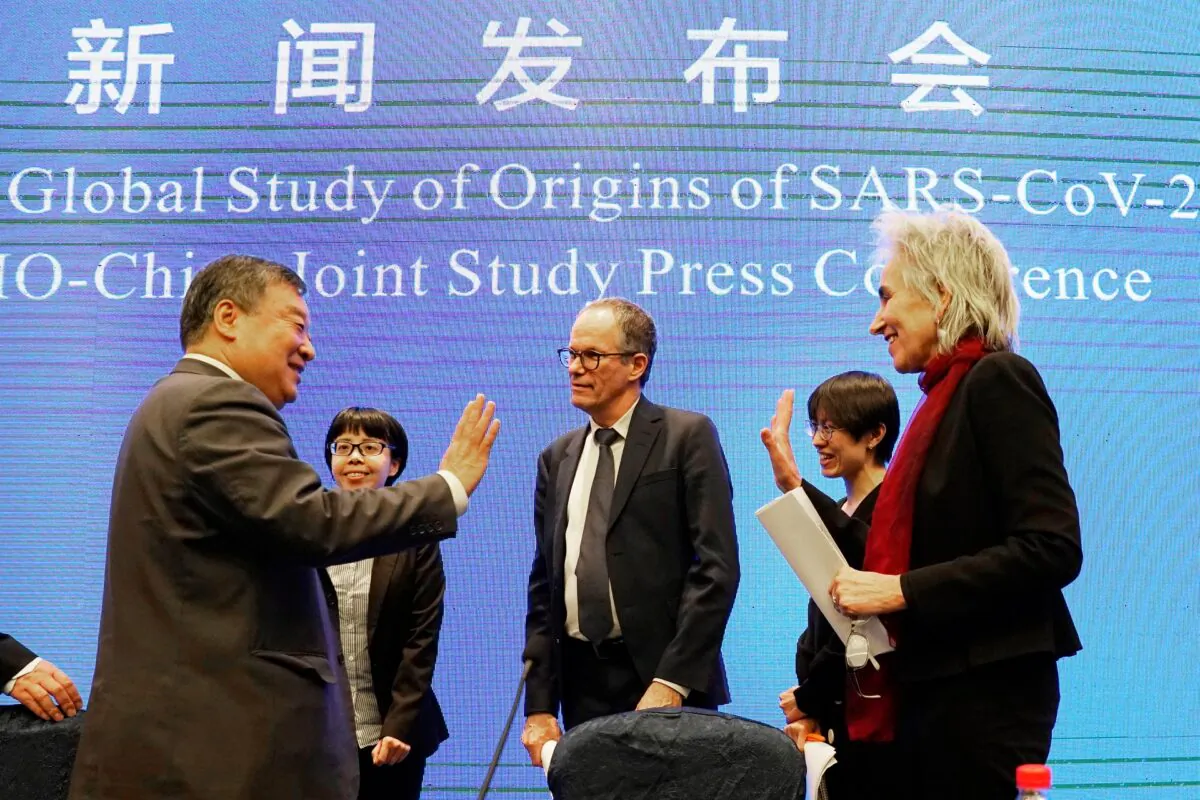 Marion Koopmans, right, and Peter Ben Embarek, center, of the World Health Organization team say farewell to their Chinese counterpart Liang Wannian, left, after a WHO-China Joint Study Press Conference held at the end of the WHO mission in Wuhan, China, on Feb. 9, 2021. (AP Photo/Ng Han Guan)