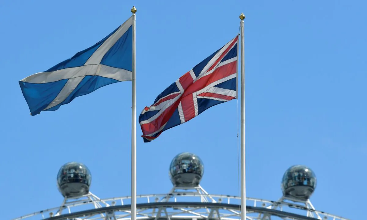 The Scottish Saltire flag flies next to the British Union Jack with the London Eye wheel seen behind in London, on July 29, 2019. (Toby Melville/Reuters)