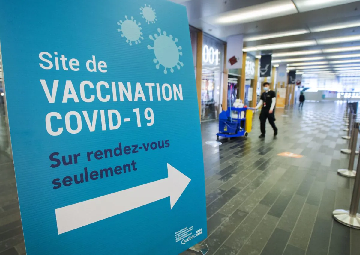 A cleaner walks through an empty mass COVID-19 vaccination site in Montreal as the wait for more doses to arrive continues, Feb. 9, 2021. (The Canadian Press/Ryan Remiorz)