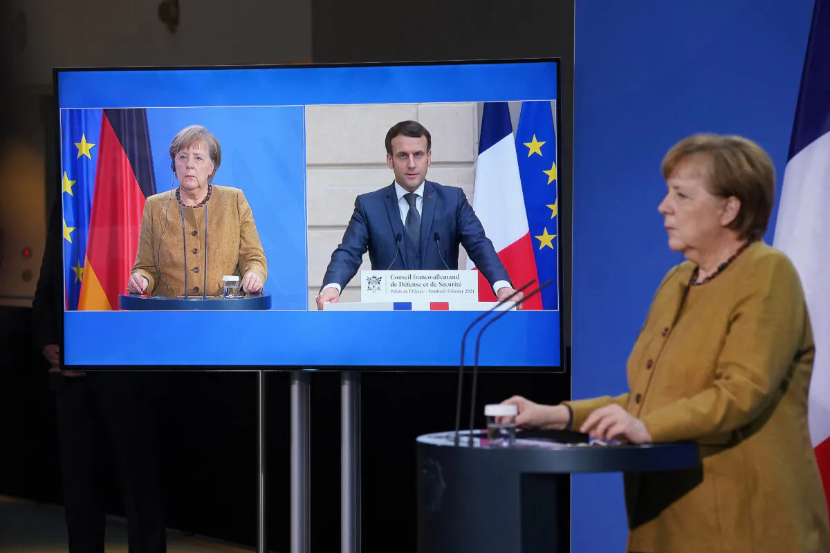 German Chancellor Angela Merkel and French President Emmanuel Macron, who is tuning in from Paris via video link, speak to the media following talks in Berlin on Feb. 5, 2021. (Sean Gallup/Getty Images)