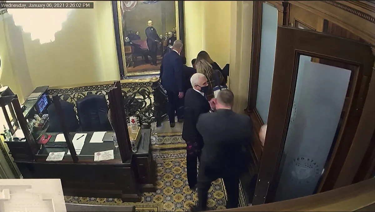 In this image from video, a security video shows Vice President Mike Pence being evacuated as rioters breach the Capitol, as House impeachment manager Del. Stacey Plaskett (D-Virgin Islands) speaks during the second impeachment trial of former President Donald Trump in the Senate at the U.S. Capitol in Washington on Feb. 10, 2021. (Senate Television via AP)