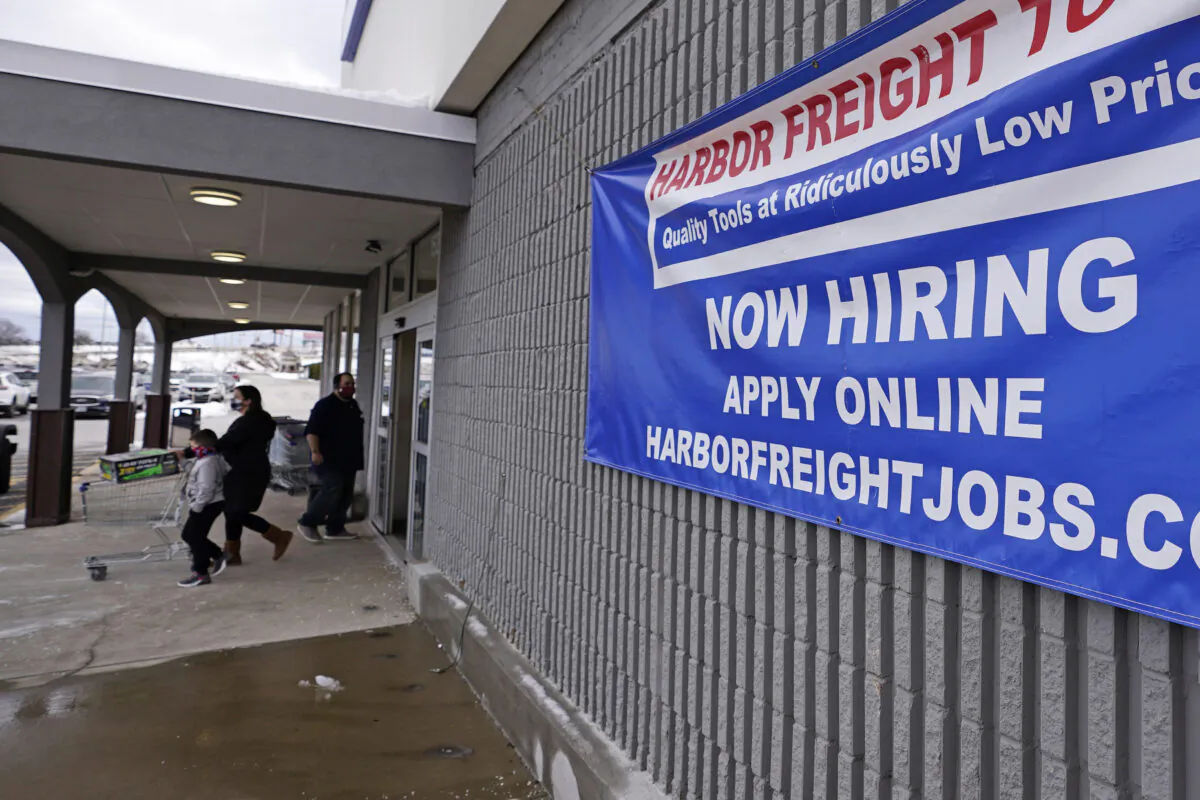 A "Now Hiring" sign hangs on the front wall of a Harbor Freight Tools store in Manchester, N.H., on Dec. 10, 2020. (Charles Krupa/File/AP Photo)