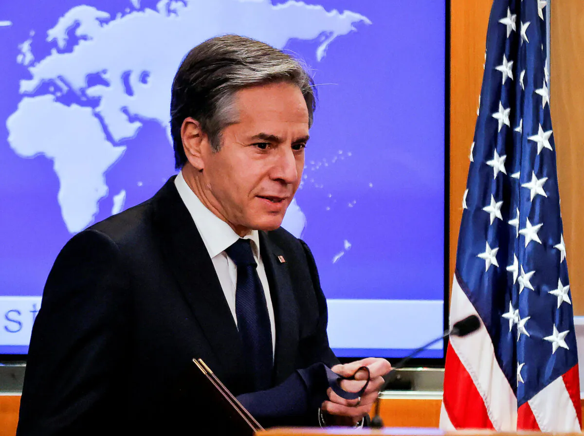 Newly confirmed U.S. Secretary of State Antony Blinken removes his face mask as he arrives to hold his first press briefing at the State Department in Washington, on Jan. 27, 2021. (Carlos Barria/Reuters/Pool/File Photo)