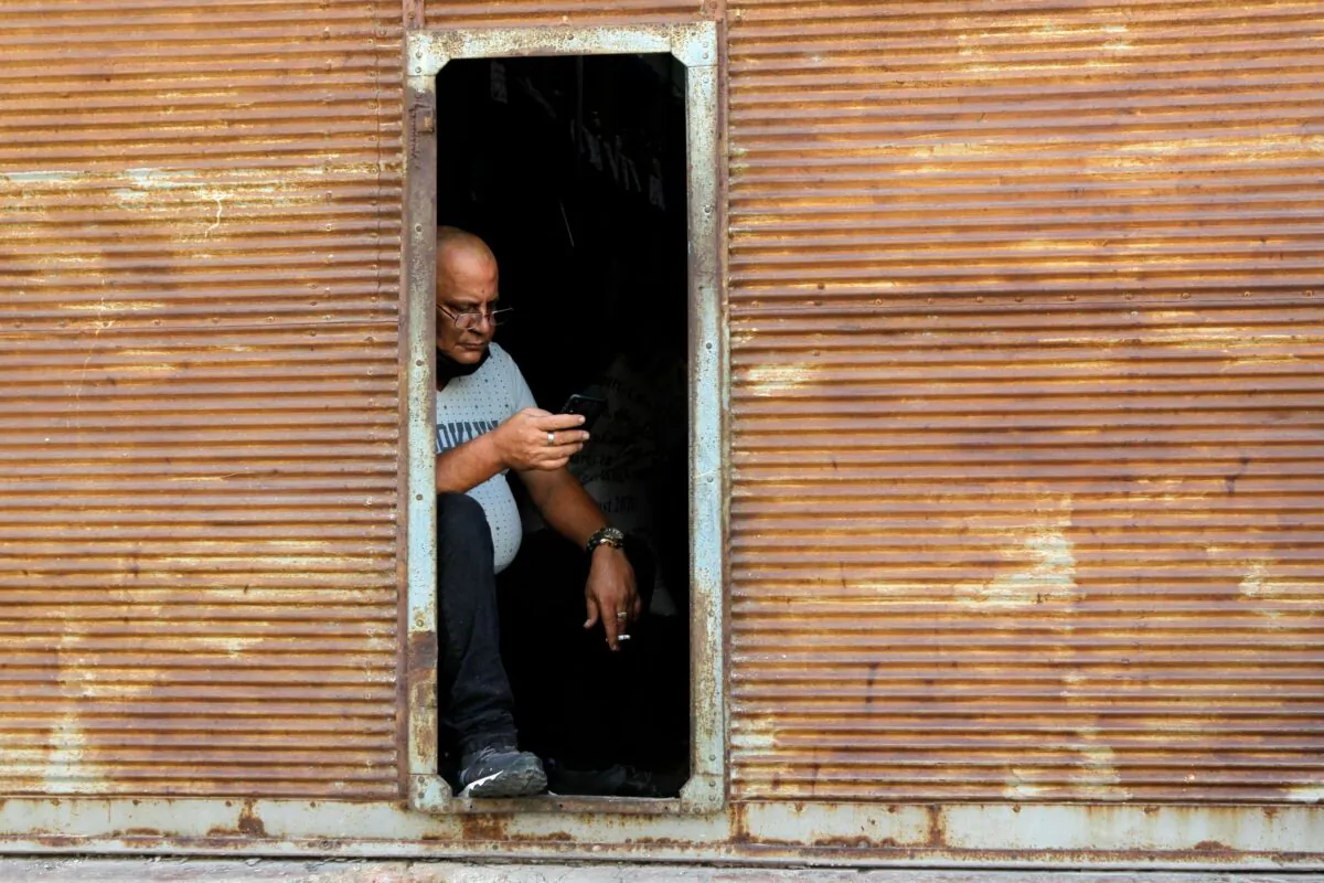 A man checks his phone as telephone and internet connections were knocked out in a nationwide failure, in Havana, Cuba, on Feb. 12, 2021. (Stringer/Reuters)