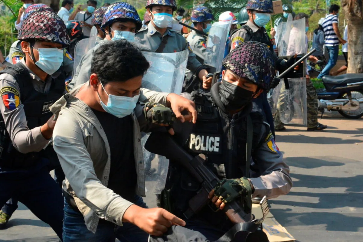 A demonstrator is detained by police officers during a protest against the military coup in Mawlamyine, Burma, on Feb. 12, 2021. (Than Lwin Times/Handout via Reuters) 