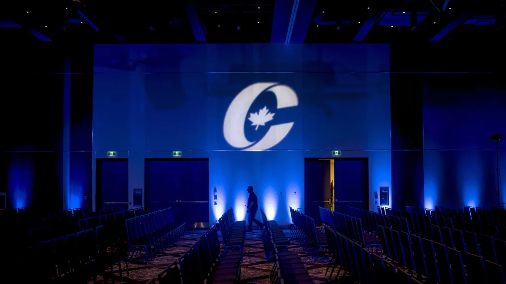 A man is silhouetted walking past a Conservative Party logo before the opening of the Party's national convention in Halifax, on Aug. 23, 2018. (Darren Calabrese/The Canadian Press)
