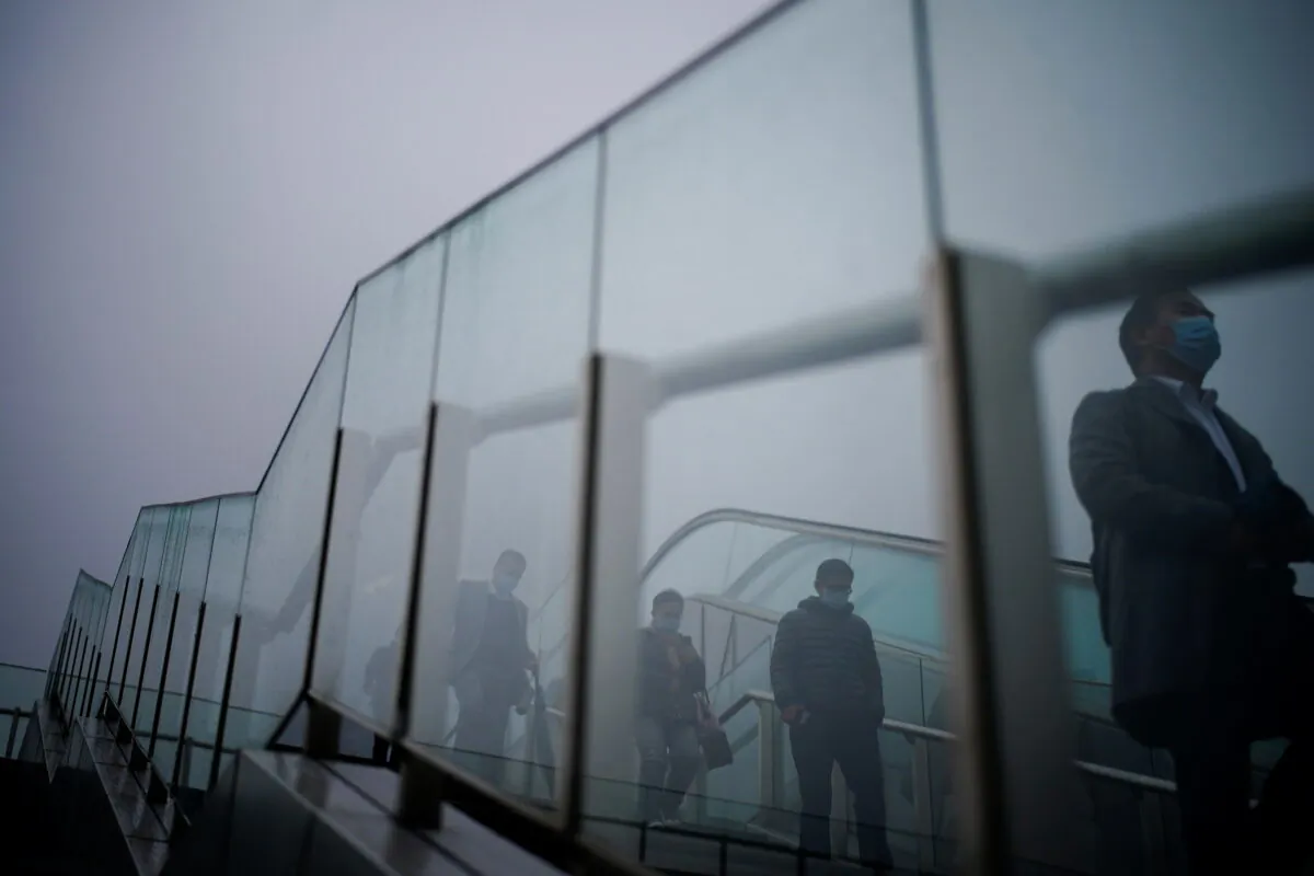 People wearing face masks descend a stairwell following the coronavirus disease (COVID-19) outbreak, in Shanghai, China on Jan. 26, 2021. (Reuters/Aly Song)