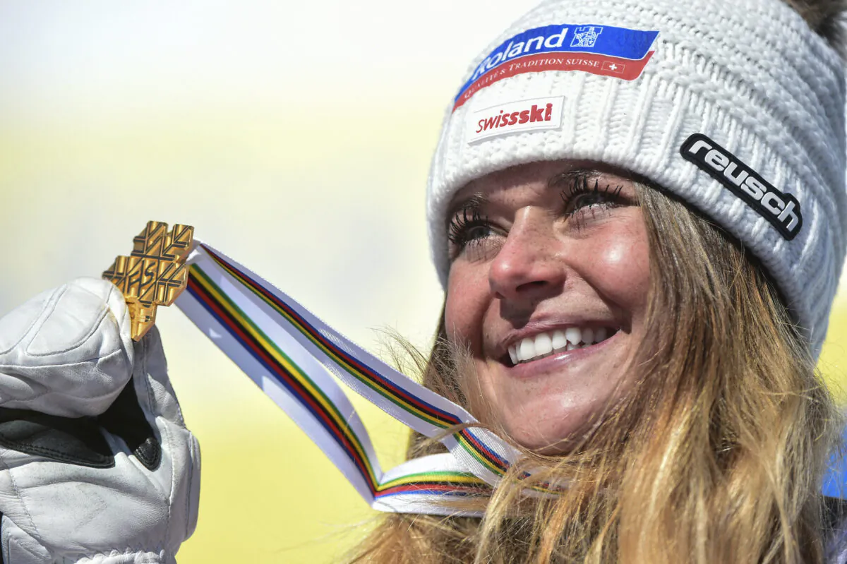 Switzerland's Corinne Suter holds the gold medal on the podium after the women's downhill, at the alpine ski World Championships in Cortina d'Ampezzo, Italy, on Feb. 13, 2021. (Marco Tacca/AP Photo)