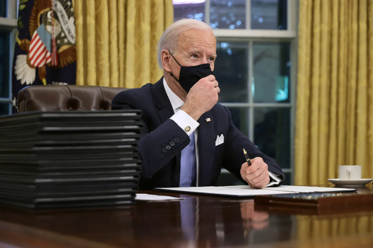 President Joe Biden prepares to sign a series of executive orders at the Resolute Desk in the Oval Office in Washington just hours after his inauguration on Jan. 20, 2021. (Chip Somodevilla/Getty Images)