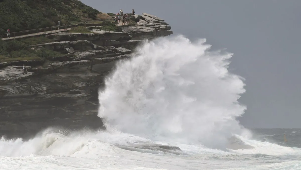 People watch the spray as large seas pound the coast near Tamarama Beach in Sydney on March 6, 2017. (William West/AFP via Getty Images)
