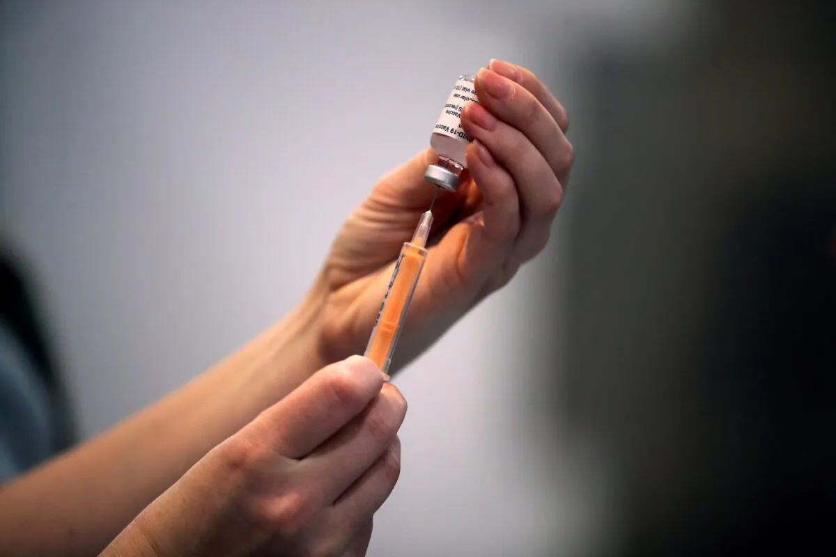 A health care worker prepares a dose of a COVID-19 vaccine at a vaccination center inside the Blackburn Cathedral, in Blackburn, England, on Jan. 19, 2021. (Molly Darlington/Reuters)