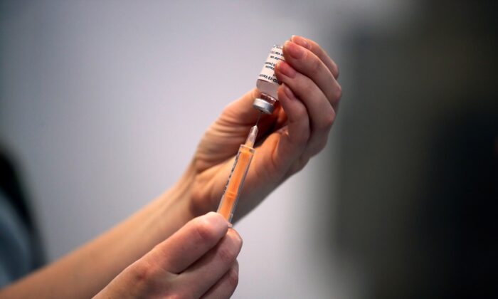 A healthcare worker prepares a dose of a COVID-19 vaccine at a vaccination center inside the Blackburn Cathedral, in Blackburn, Britain, on Jan. 19, 2021. (Molly Darlington/Reuters)