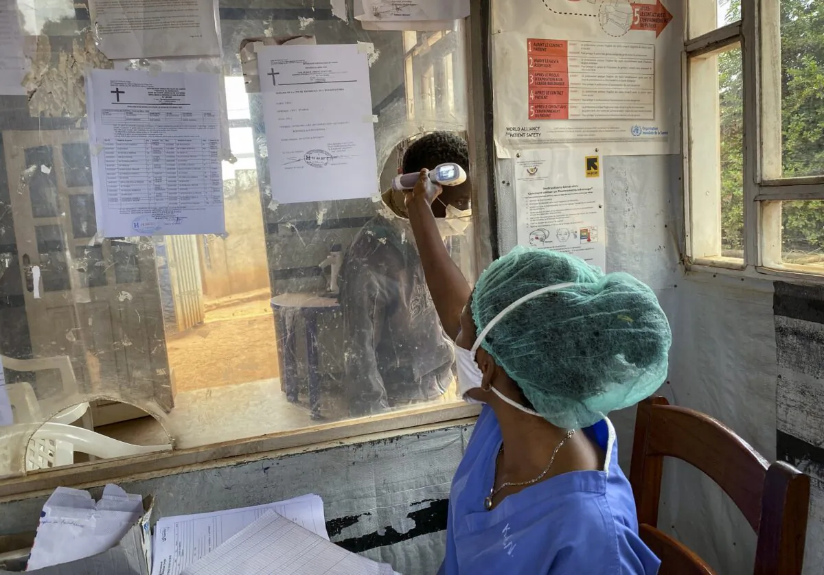 A medical worker checks a person's temperature at the Matanda Hospital in Butembo, where the first case of Ebola died, in the North Kivu province of Congo, on Feb. 11, 2021. (Al-hadji Kudra Maliro/AP Photo)