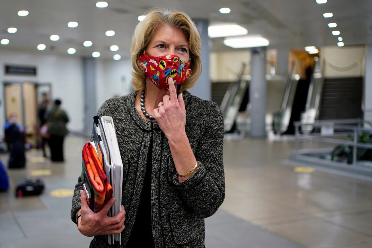 Sen. Lisa Murkowski (R-Alaska) points to her a Batman mask as she departs after House impeachment managers rested their case in impeachment trial of former President Donald Trump, on charges of inciting the deadly attack on the U.S. Capitol, on Capitol Hill in Washington on 11, 2021. (Joshua Roberts/Reuters)