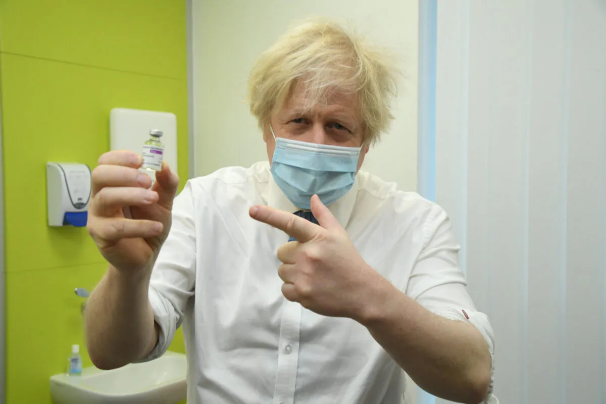 Britain's Prime Minister Boris Johnson poses with a vial of AstraZeneca/Oxford COVID-19 vaccine during a visit to a coronavirus vaccination hub at the Health and Wellbeing Centre in Orpington, southeast London, on Feb. 15, 2021. (Jeremy Selwyn /POOL/AFP via Getty Images)