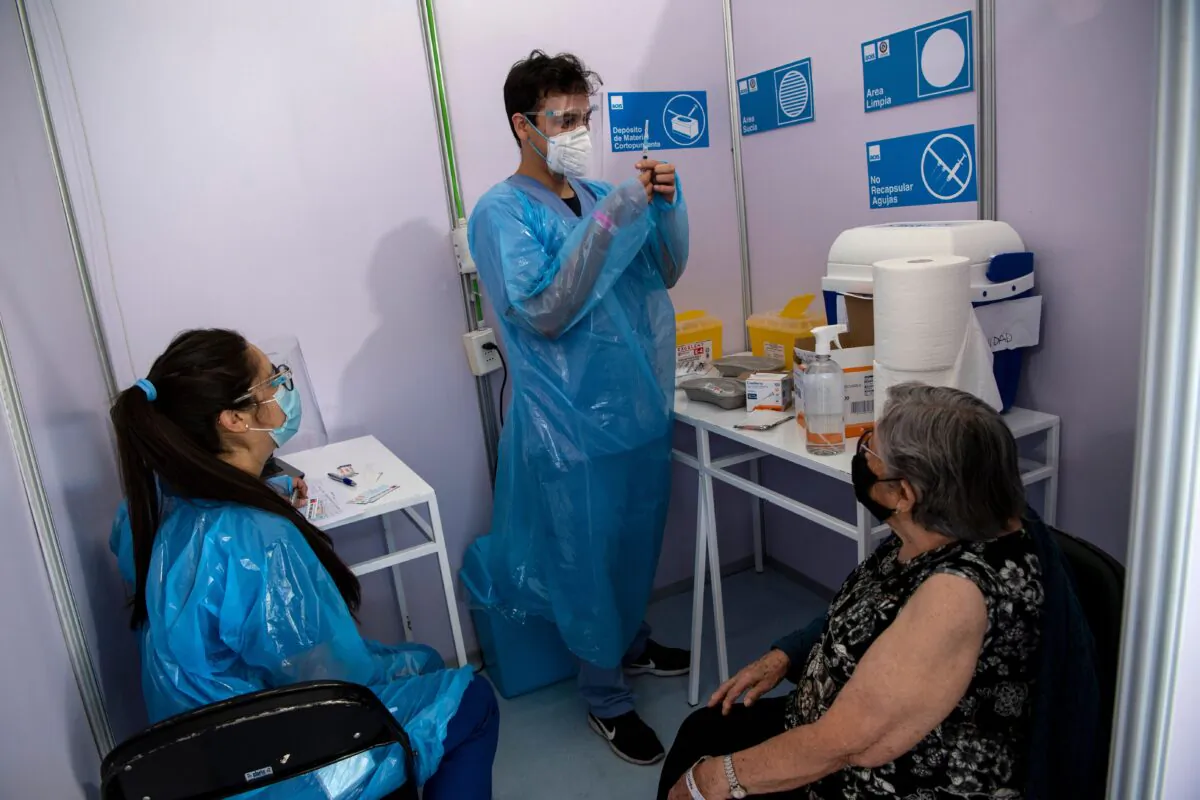 A healthcare worker prepares to administer a dose of China's Sinovac CoronaVac vaccine to a person at a vaccination centre mounted at the Bicentenario Stadium in Santiago, Chile on Feb. 3, 2021. (Martin Bernetti/AFP via Getty Images)