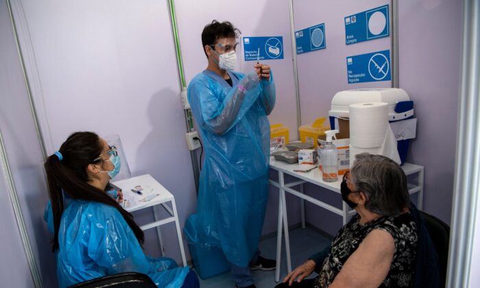 A healthcare worker prepares to administer a dose of China's Sinovac CoronaVac vaccine to a person at a vaccination centre mounted at the Bicentenario Stadium in Santiago, Chile on Feb. 3, 2021. (Martin Bernetti/AFP via Getty Images)