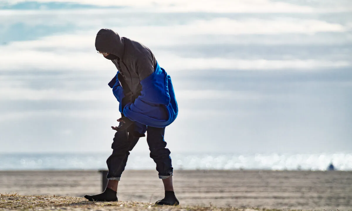 A homeless man walks along Venice Beach in Los Angeles on Jan. 27, 2021. (John Fredricks/The Epoch Times)