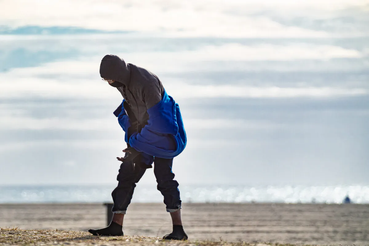 A homeless man walks along Venice Beach in Los Angeles on Jan. 27, 2021. (John Fredricks/The Epoch Times)